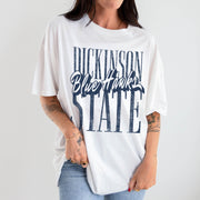 Person wearing a white t-shirt with text "Dickinson State Blue Hawks" on a plain background