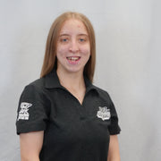 Person wearing a black polo shirt with logos on a gray background